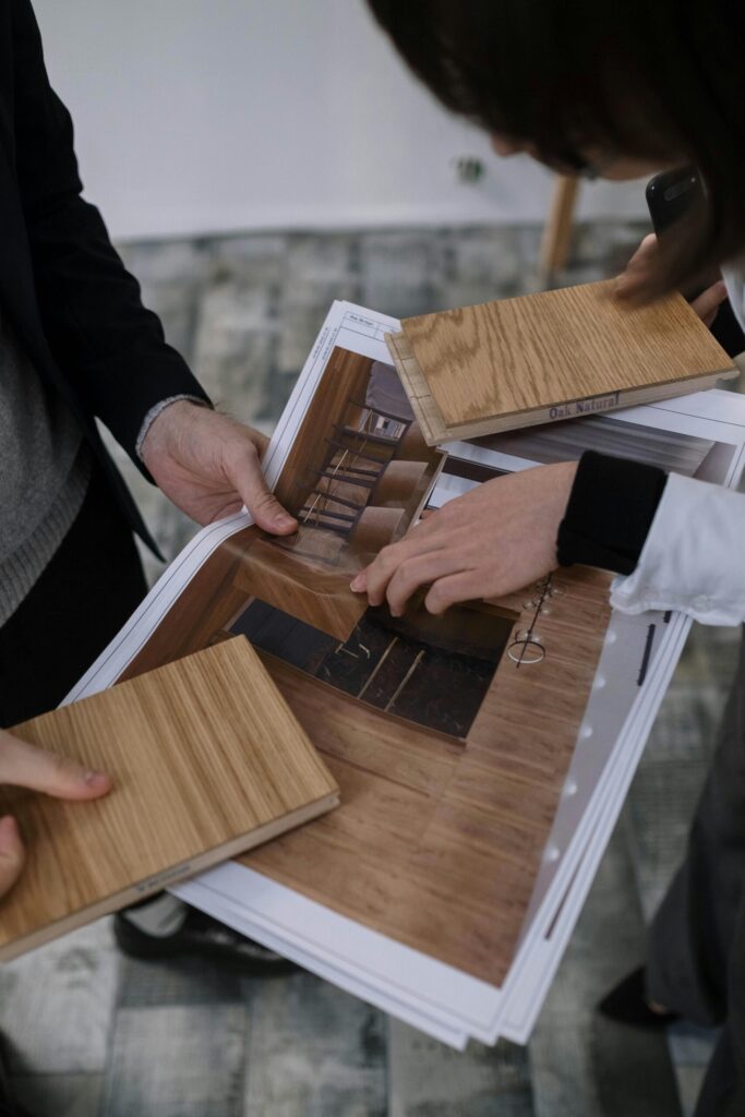 Hands comparing wood samples with a design layout